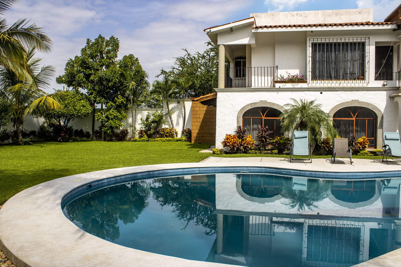 Alberca de La Hacienda con fachada colonial y balcones de herrería