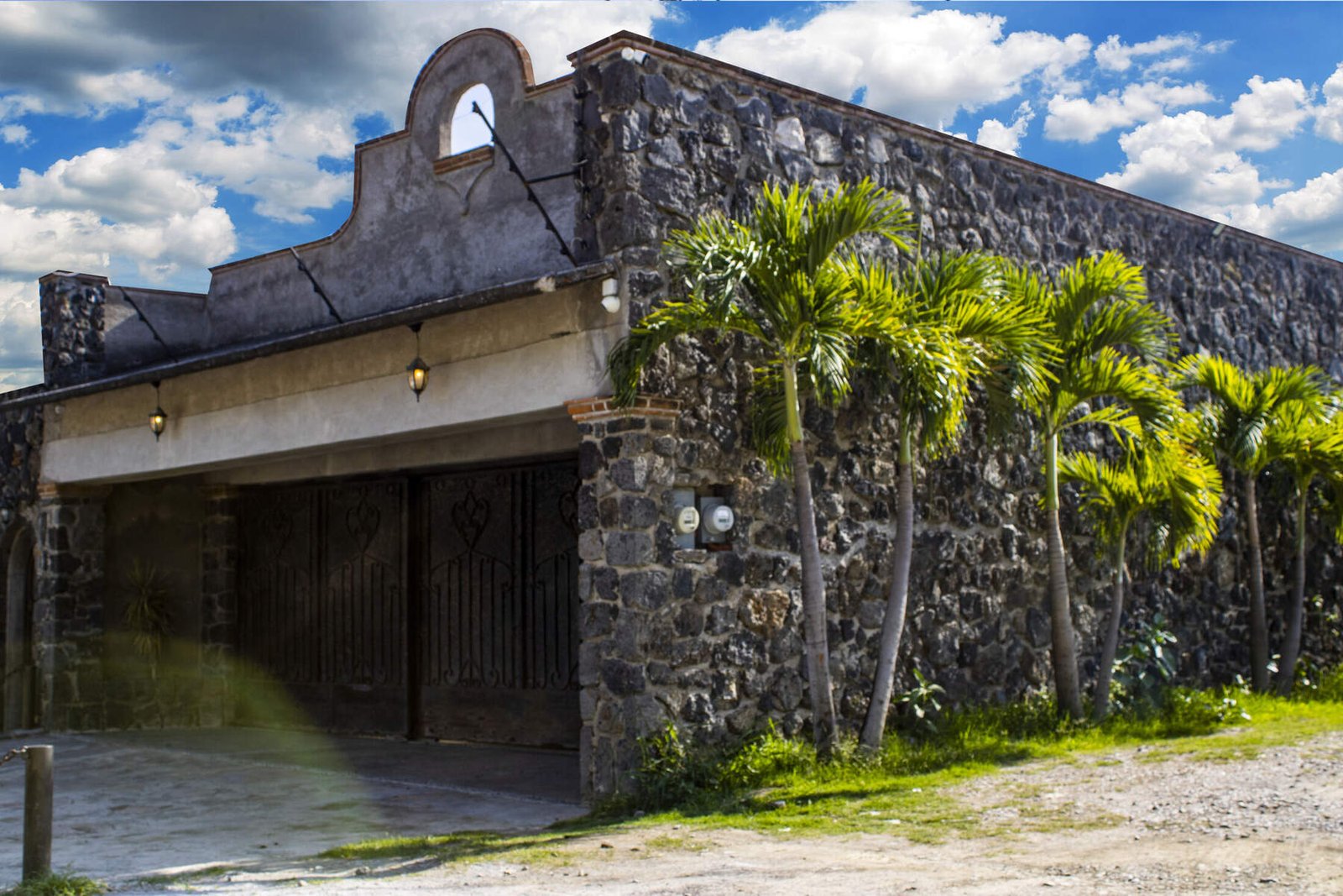 Fachada de cantera y portón de herrería en la entrada de La Hacienda