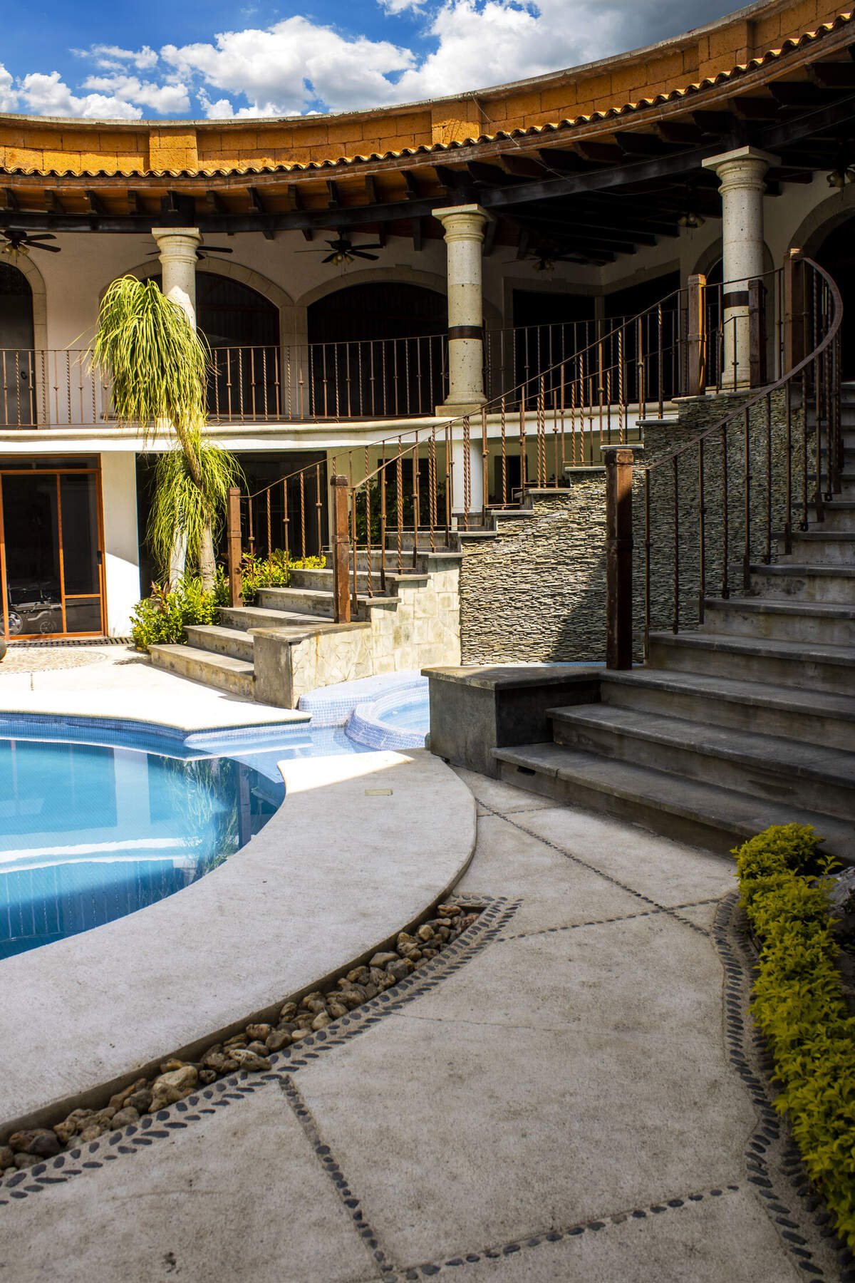 Terraza y escalinata junto a la alberca y el jacuzzi