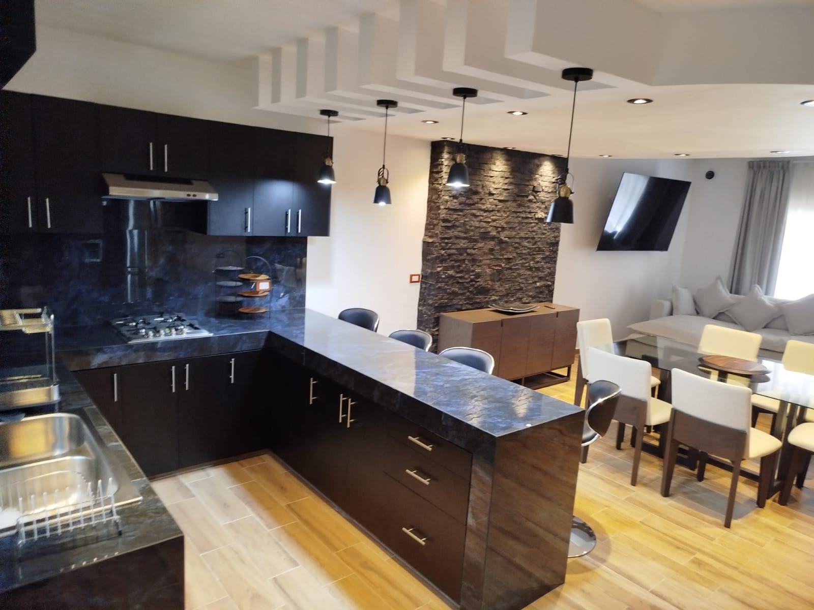 Cocina equipada con isla, barra y comedor integrado — Villas del Descanso